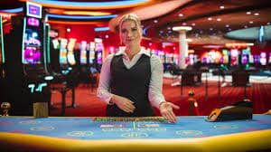 Dealer profesional kami di studio Live Sic Bo dengan tiga dadu dan meja permainan